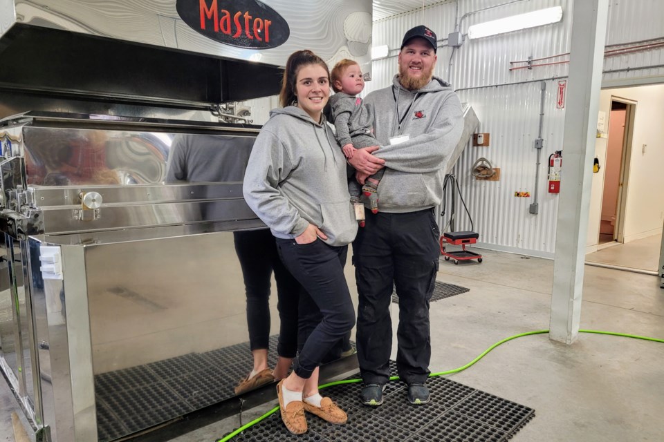 Erica and Spencer Hogan with daughter Emma (1 year) in front of their state-of-the-art evaporator.