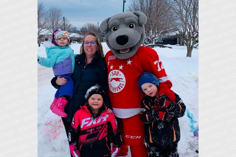 A cook by day and a mascot by night, Corey Deschene, aka 'Dash,' is pictured with his wife Courtney and three of their four grandchildren.