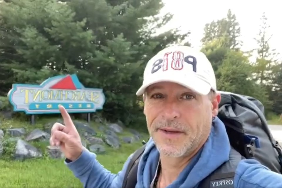 Prior to entering the U.S. on a cross-country road trip in an RV last November, Jeff Primeau uploaded photos and video of himself going on a walk from Searchmont to London; he's pictured in this photo from September 2023 in front of the Searchmont Resort sign at the beginning of his walk 