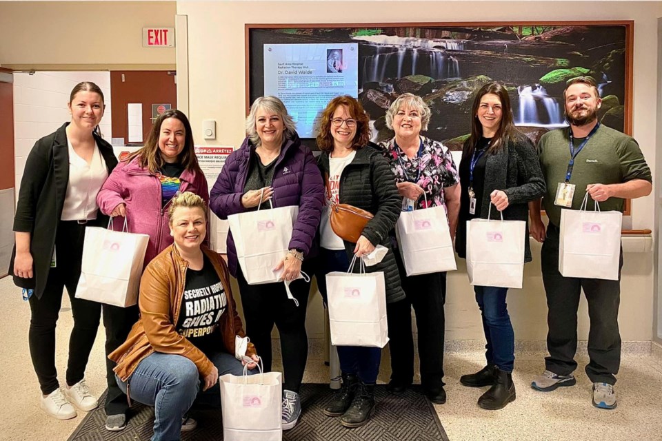 Holly Reynolds (Patient Care manager), Jen O’Reilly (radiation therapist), Khris King, Lynne Palumbo, Karen Brunetta, Kristy Johnson (social worker), Rob Rawn (social worker) and Debbie Fagan are pictured at the Sault Area Hospital during Breast Friends first handoff of 50 gift bags for patients who are travelling to Sudbury to receive radiation treatment. 