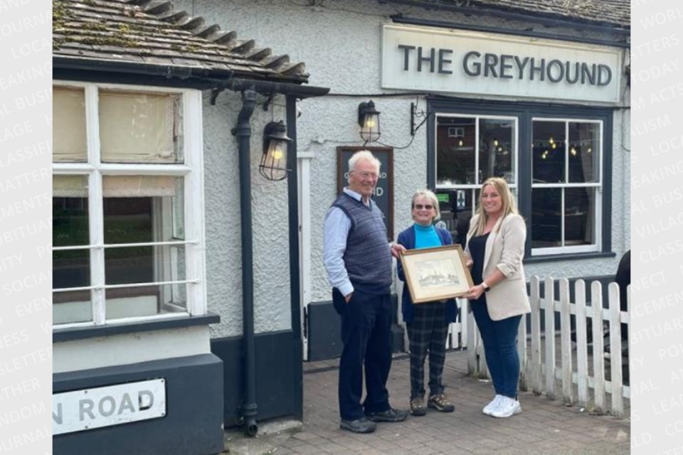 The Sault's Dr. John Marrack presents a 132-year-old painting of the Claydon Greyhound to pub staff near Ipswich in England.