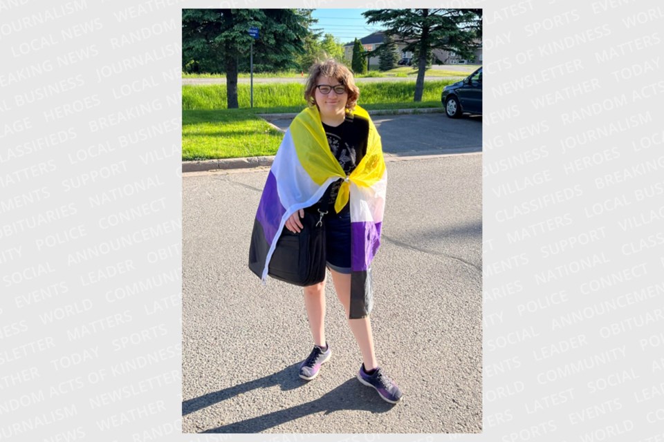Kelsey Moran proudly wears their non-binary flag as a cape. 