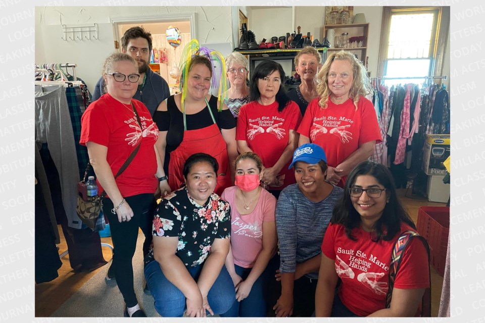 Helping Hands board of directors and volunteers gather with founder Wendy Gutcher at their new home on Wellington Street West.
