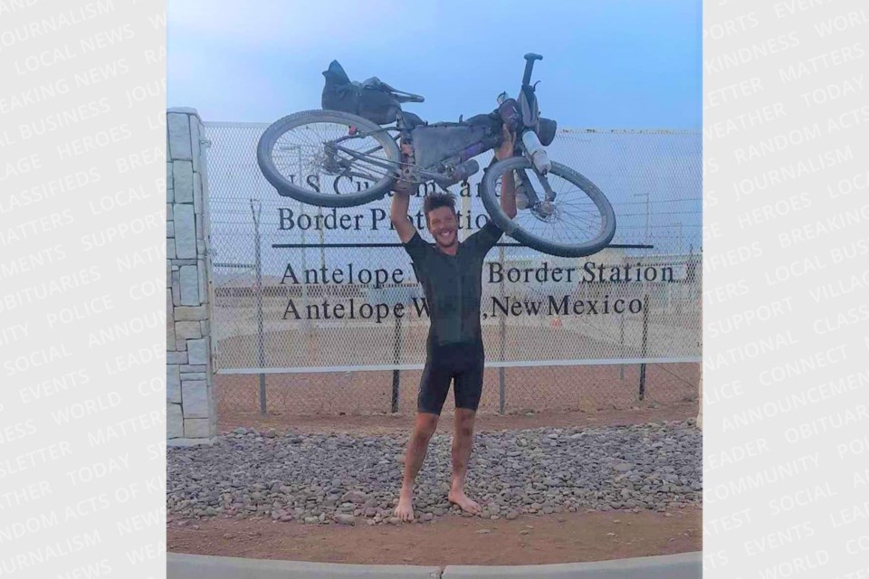 The Sault's Joel Wenham (pictured) proudly holds his bike up high at the U.S.- Mexico border in Antelope Wells, New Mexico following his completion of the 4,400 km-long Tour Divide race on Jun. 30, 2023