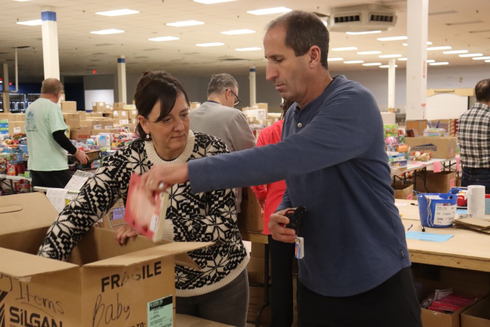 Volunteering for the first time with Christmas Cheer this year, long-time friends and recent retirees Cindy MacKay (left) and Mike McKinley (right) say the last several weeks of helping out at the Station Mall depot have been an incredibly rewarding time.