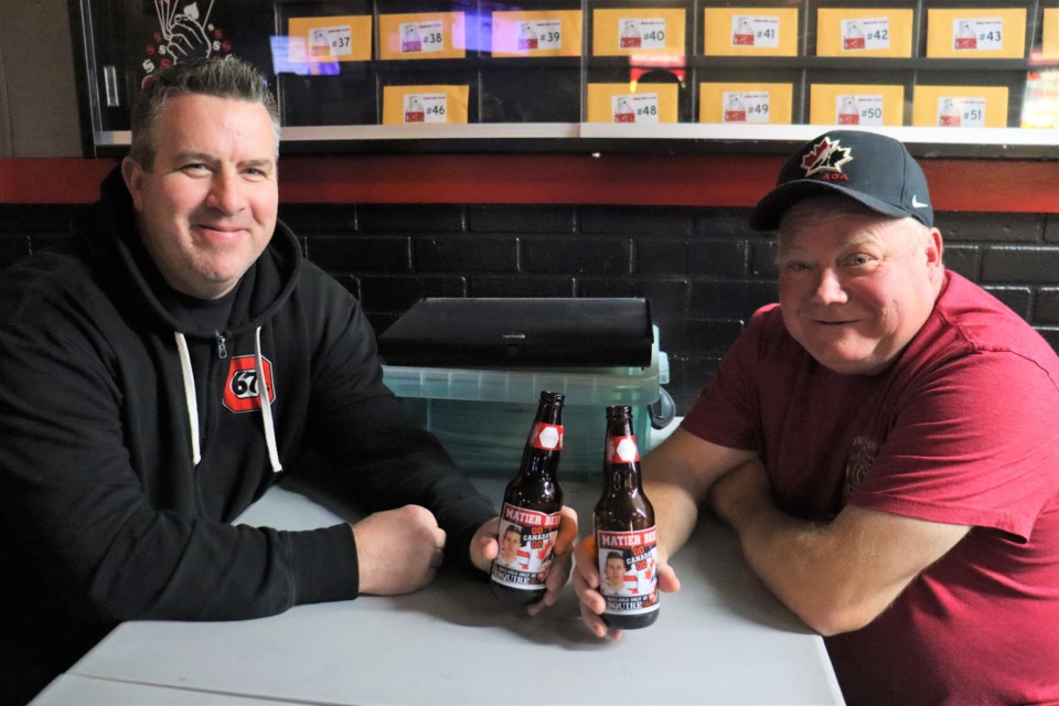 Jack Matier's dad Mark (left) and Esquire Club spokesperson Matt Patreau (right) enjoy the first two beers featuring the promotional decal of the Sault native and Ottawa 67's defenseman ahead of this year's World Junior Hockey Championship. 