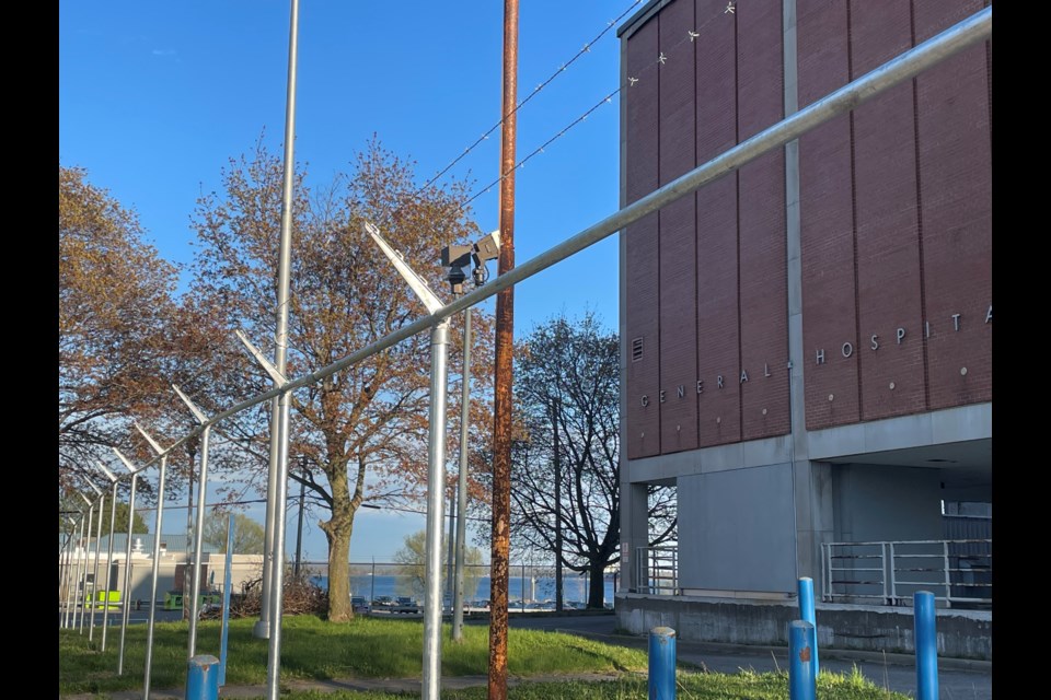 Workers have begun installing a barbed-wire fence around the old hospital site on Queen Street East. May 11, 2024.