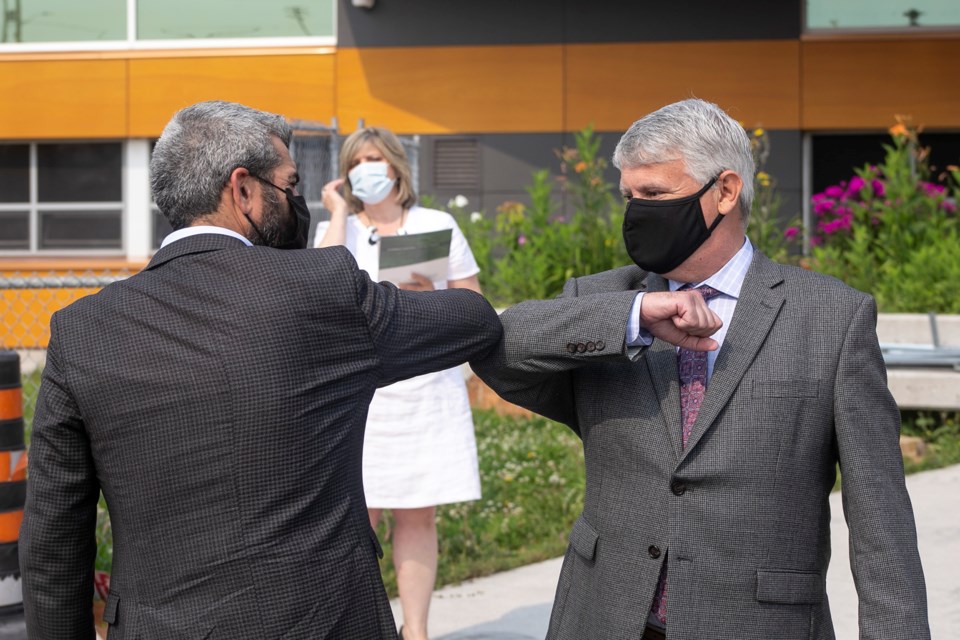 Sault MP Ross Romano (left) greets MP Terry Sheehan with an elbow bump at a joint federal and provincial funding announcement on Tuesday at Kiwedin Public School Kenneth Armstrong/SooToday