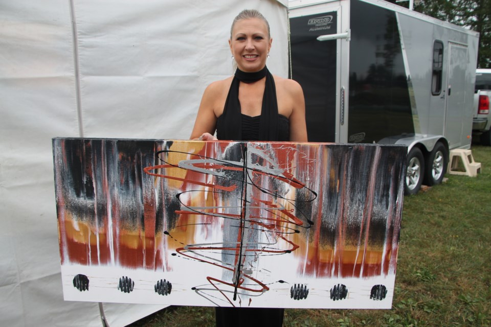 Donna Gioia, owner/operator of 'Wine for your Walls,' displays one of her paintings at Art in the Park, August 20, 2016. Darren Taylor/SooToday