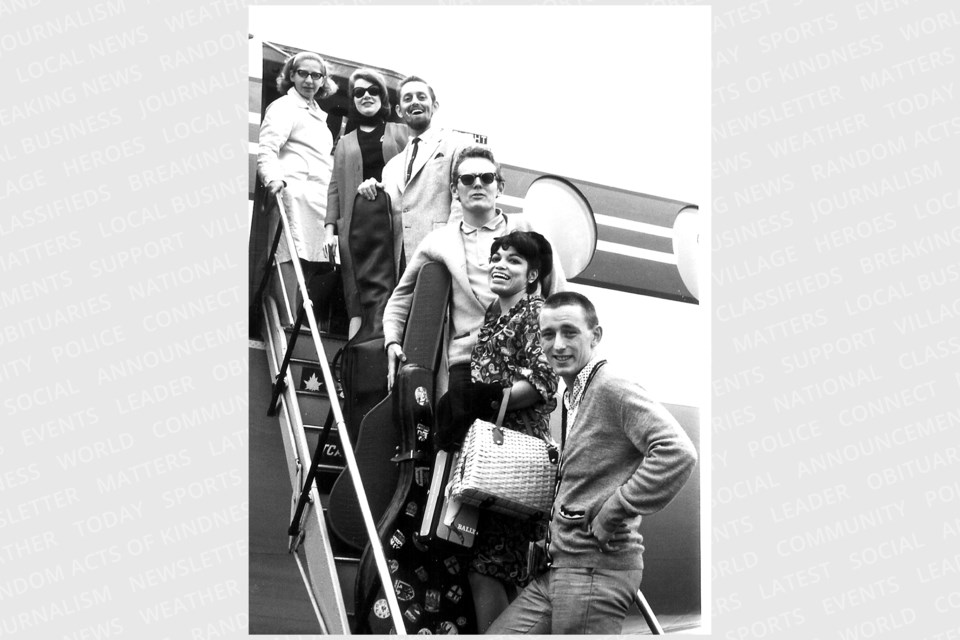 Gordon Lightfoot (centre, with sunglasses) boards an airplane with other folk artists the morning after a Sault Ste. Marie folk festival. 