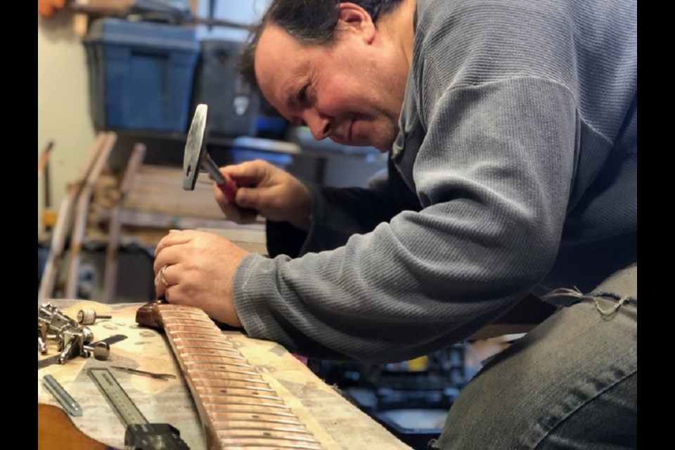 Jon Uebele, owner of Jubilee Original Guitars, works on a new guitar. 