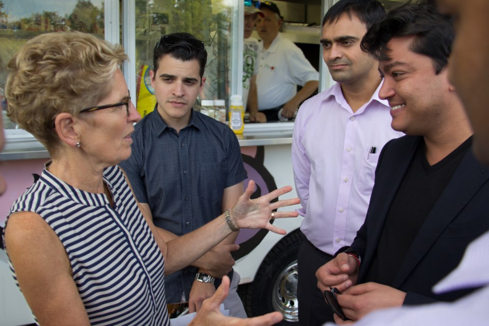 Ontario Premier Kathleen Wynne chinwags last night in Bellevue Park with Ward 3 Councillor Matthew Shoemaker and Essar Global's Amar Kapadia and Rewant Ruia. Photo by Jeff Klassen/ SooToday.
