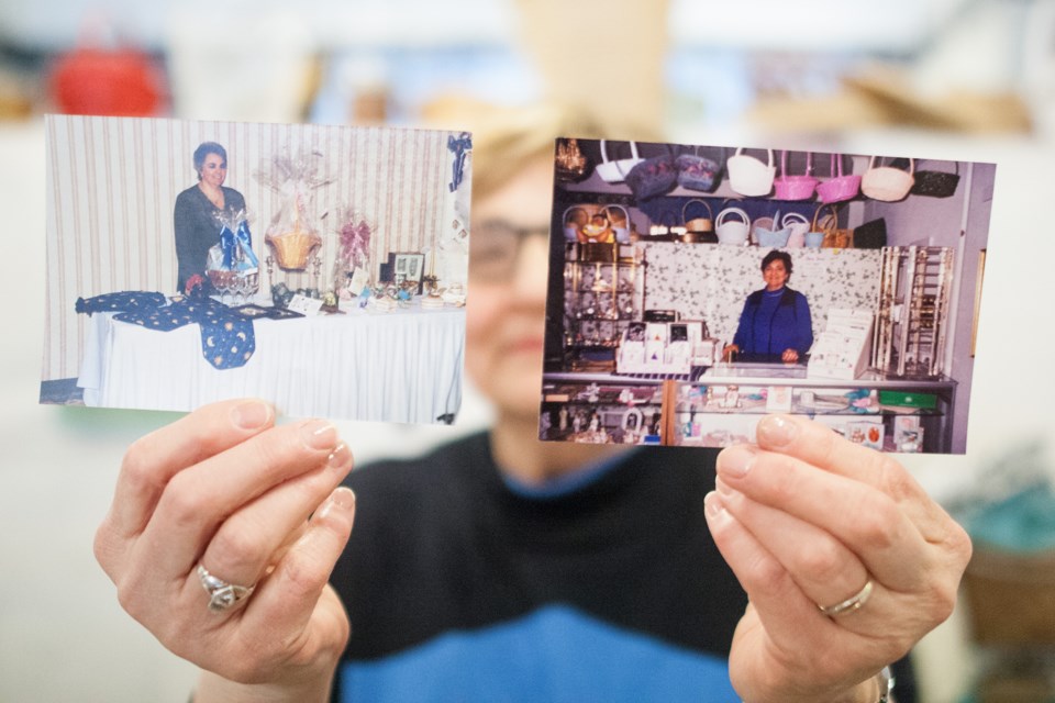 Store owner Julia Lamberts holds up 1990s-vintage photos of her cousin Janice Gagnon and herself from behind the counter of their Queen Street Store. Ideal Concept In Gift Giving closes this Saturday after more than 28 years of business. Kenneth Armstrong/SooToday