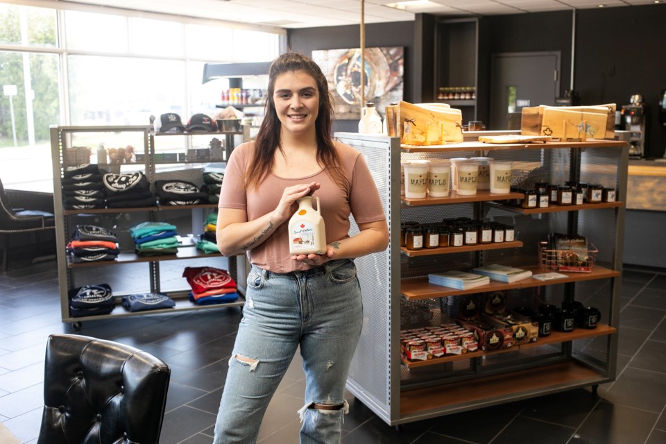 Hogan's Homestead co-owner Erica Horgan shows off some of her company's signature maple syrup, one of the many locally sourced gifts available at a new restaurant and gift shop at the Sault Ste. Marie Airport.