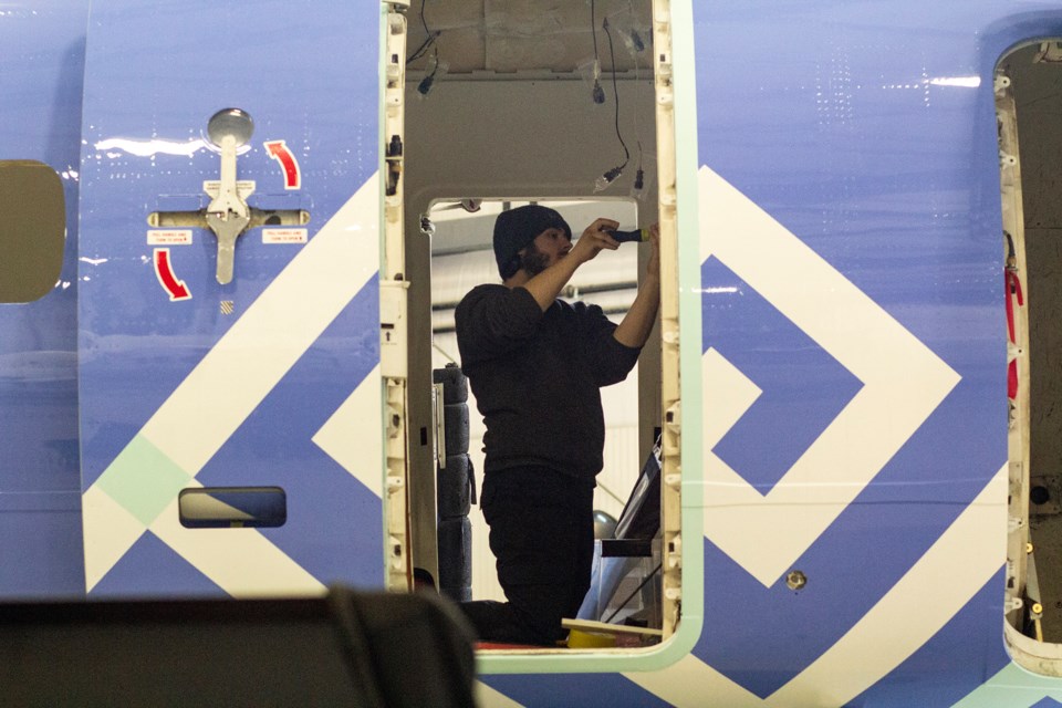 A worker makes an adjustment inside an aircraft at JD Aero Technical, an aircraft repair and refurbishment facility in Sault Ste. Marie.