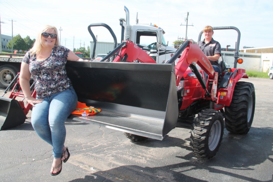 Stephanie Smith, Service Rentals and Sales accounting department, gets ‘scooped up’ by Jenn McGonegal, Service Rentals and Sales service manager, at the wheel of a heavy equipment vehicle, June 27, 2018. Darren Taylor/SooToday