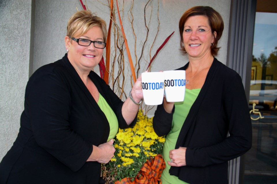 Debbie Jo Linklater, Arthur Funeral Home – Barton & Kiteley Chapel funeral director, and Joni Cooke, Arthur Funeral Home – Barton & Kiteley Chapel funeral director and manager, with their complimentary SooToday coffee mugs, Oct. 5, 2018. Darren Taylor/SooToday