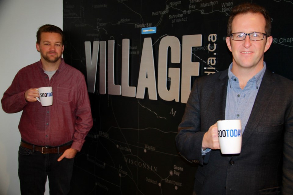 Jeff Elgie, Village Media CEO (at right), and Jake Cormier, Village Media director of finance and operations with their SooToday mugs. Darren Taylor/SooToday 