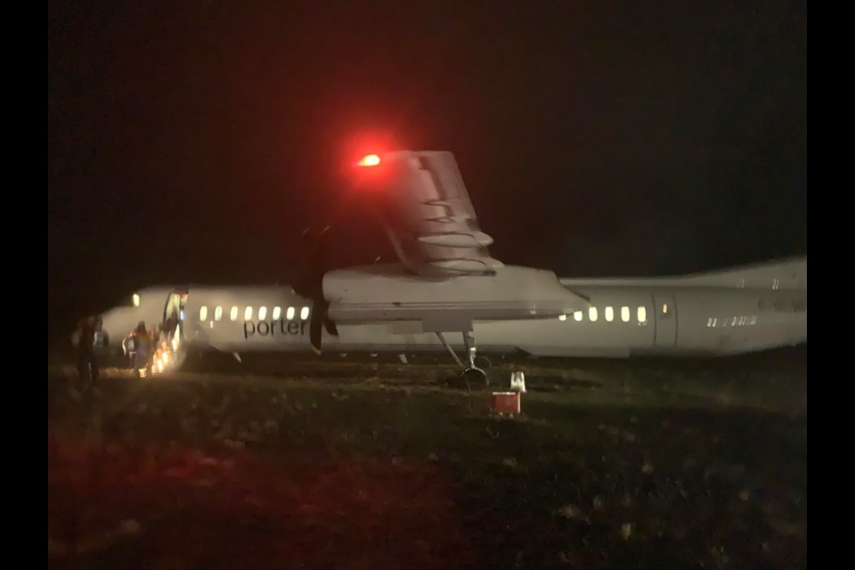 A reader-submitted photo shows a Porter Airlines aircraft sitting beside a runway at the Sault Ste. Marie Airport after it skidded off the runway during a late evening landing, April 16, 2023.