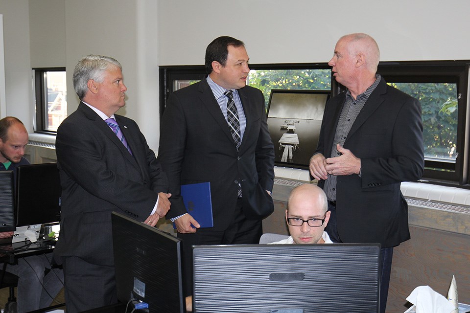 MP Terry Sheehan (left), Mayor Christian Provenzano (middle) and Insightworks founder and CEO Mark Lewis discuss a project being worked on by Insightworks' Zach Frair. Derek Turner photo