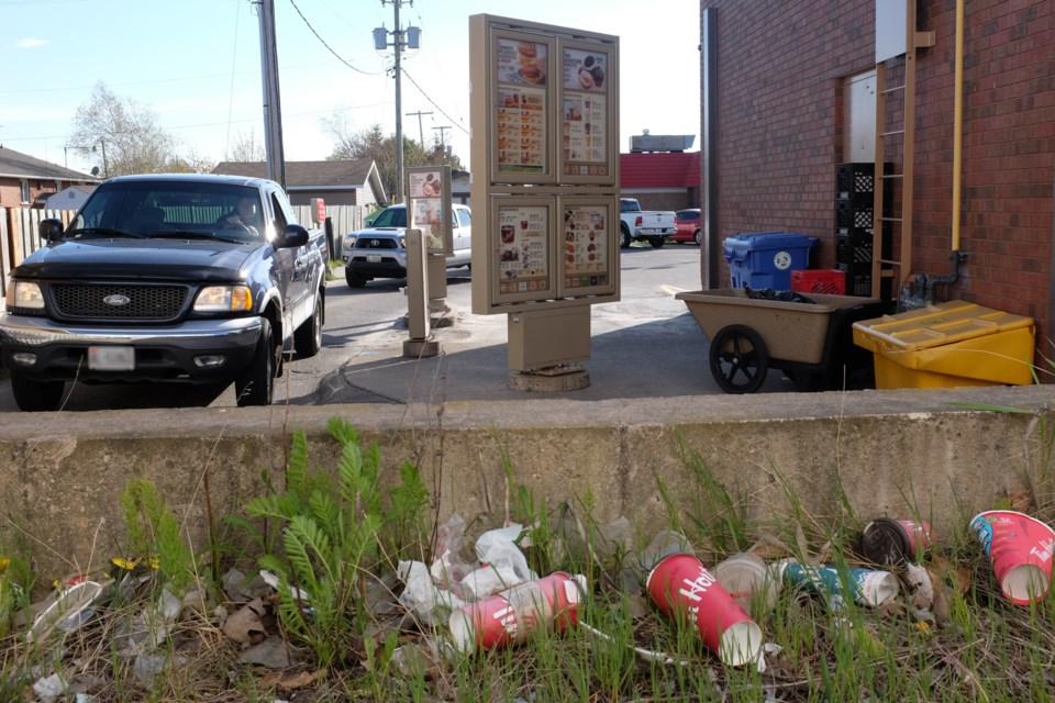 Discarded coffee cups were observed in the grass beside the drive-thru of the Tim Hortons at 191 Trunk Rd. The location removed its garbage and recycling bins from its drive-thru last week in what appears to be part of a Canada-wide “waste diversion program”. Photo by Jeff Klassen for SooToday