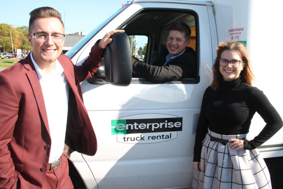 Jordan Connors, the Sault’s Enterprise Truck Rental manager, with Lauren Moore, assistant manager, joined by Matt Ross (Ottawa-based Enterprise group truck manager, seated at the wheel of an Enterprise van), Oct. 9, 2019. Darren Taylor/SooToday