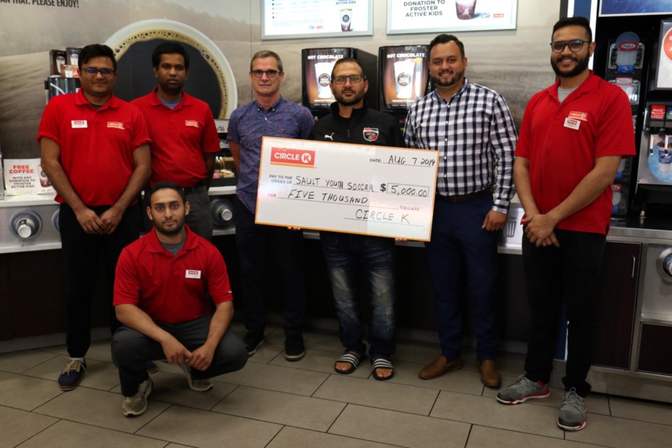 Sault Youth Soccer Club President Steve Mazucca (middle) is joined by Circle K Market Manager Palmer Maniacco (left), Circle K representative Tyler Ramsawack (right) and Circle K staff members during Wednesday's cheque presentation. James Hopkin/SooToday 