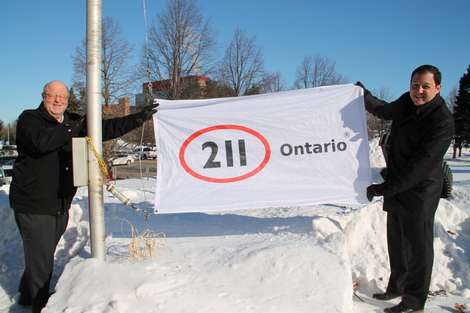 Sault Ste. Marie United Way CEO Gary Vipond and Sault Mayor Christian Provenzano get set to raise the 211 flag at the Civic Centre, February 11, 2016. Darren Taylor/SooToday