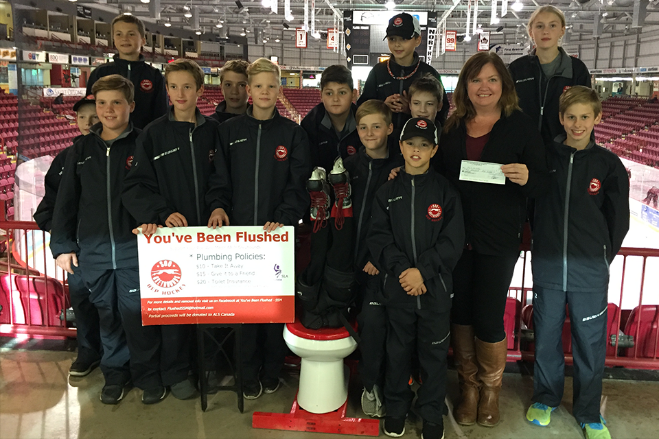 The Pee Wee Major AA Jr. Greyhounds present a cheque for more than $2,200 to Brigitte Labby, ALS Canada Regional Manager.