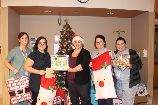 Amanda Johnston and Heather Hilderley-Phillips, second and third from left, delivered over $9,000 in gifts to sick children and their parents at Sault Area Hospital on Friday, Dec. 23, 2016. Photo supplied.
