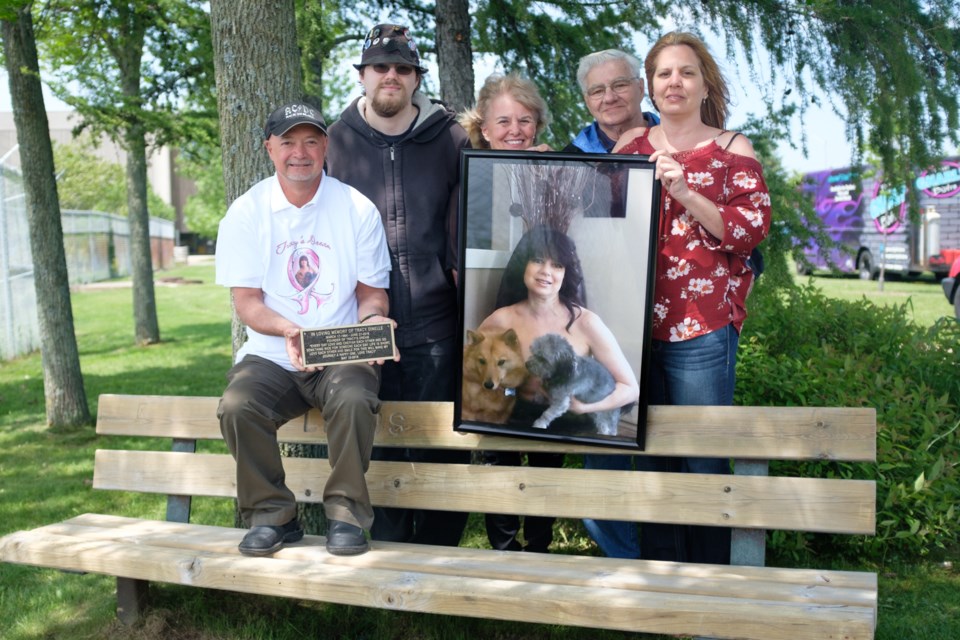 The family of Tracy Dinelle holding her image on the bench that was dedicated to her on Saturday. (From left) husband Dennis Dinelle, son Tyler Dinelle, mother Rena Ross, father Jackie Particelli, and sister Carla Particelli. Carla and Jackie were both diagnosed with cancer within just two years of Tracey. Jeff Klassen/SooToday