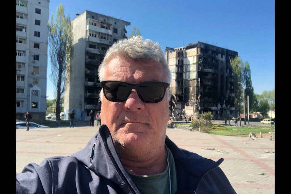 The Sault’s Robert Peace is seen here with bomb-damaged buildings in Ukraine.