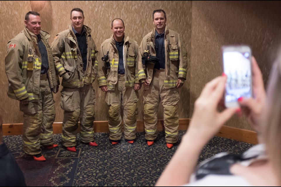 Sault Ste. Marie Fire Services' (from left) Richard Bishop, Graeme Pateman, Jeremy Van Hook, and Brian Turpin pose for photos. Fire fighters and and police officers wore red high heel shoes at the official launch of Women in Crisis (Algoma)'s Walk a Mile in her Shoes Campaign on Thursday night. Jeff Klassen/SooToday