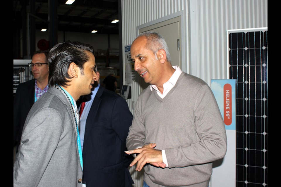 Martin Pochtaruk (left), President of Heliene Inc., speaks with a visiting senior economic officer. Submitted photo