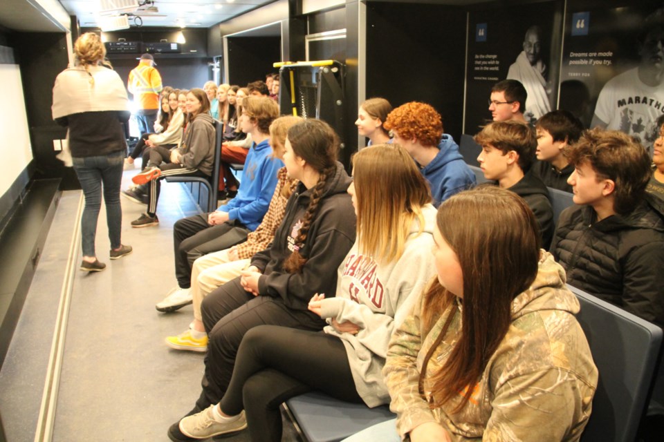 Korah Collegiate Grade 10 students listen to Friends of Simon Wiesenthal Center for Holocaust Studies educator Kim Quinn aboard the Tour for Humanity bus, March 28, 2023.  