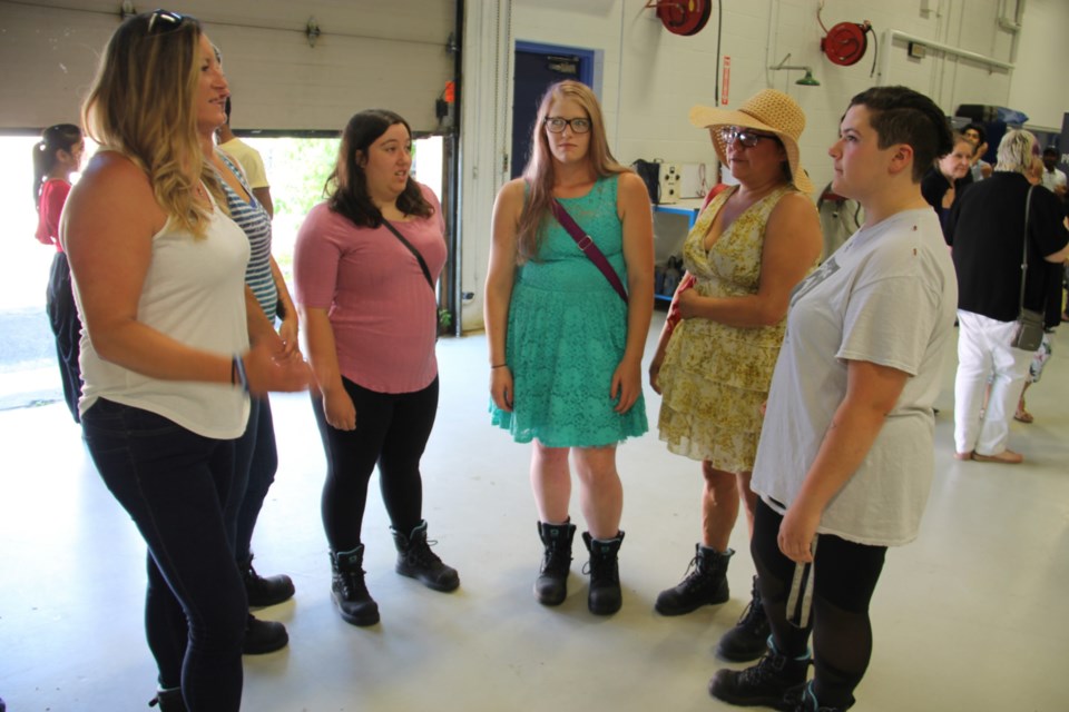 Women involved in Sault College’s Pre-Trades And Technology program chat with their work boots on before a funding announcement from Sault MPP Ross Romano, July 19, 2019. Darren Taylor/SooToday 