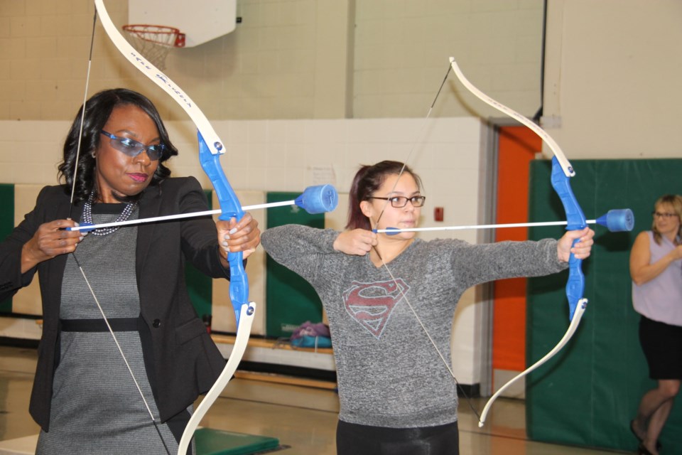 Mitzie Hunter, minister of education, tries her hand at some indoor archery on a visit to the Urban Aboriginal School in Sault Ste. Marie, Jan. 23, 2017. Darren Taylor/SooToday
