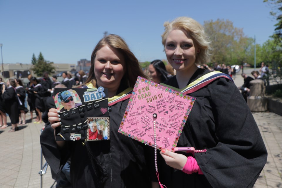 Erica Kennis (left) and Brittney Drouin (right) before the Algoma University Convocation ceremony on Saturday. Friends and classmates for six years, Kennis and Drouin lost their fathers on the same day in April this year. Photo by Jeff Klassen for SooToday