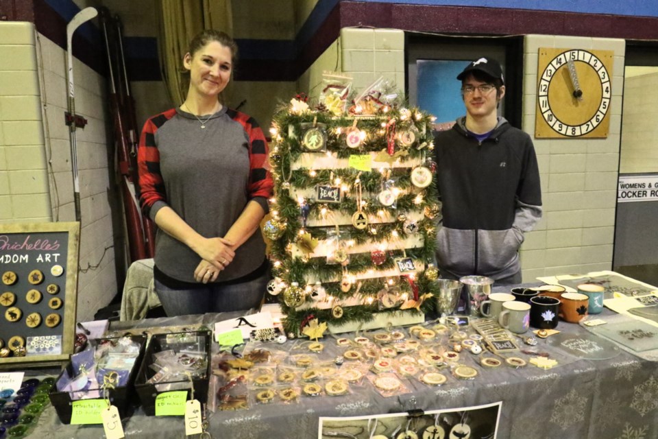 Michelle Archibald, left, and son Dylan set up a booth for Michelle's Random Art during Sunday's holiday bazaar at the YMCA. James Hopkin/SooToday