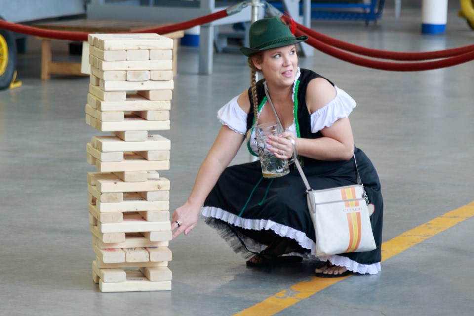 Dressed in dirndl and just about ready to fill up her stein, Ashley Seeler plays a festival-sized version of Jenga during 2017 Oktoberfest at the Canadian Bushplane Heritage Centre on Saturday. Jeff Klassen/SooToday