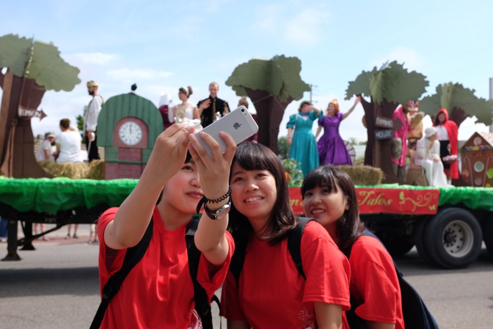 Young women take a selfie in front of a float at last year's Rotaryfest parade. Photo by Jeff Klassen for SooToday