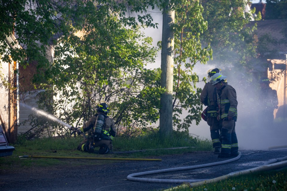 Firefighters apply water on an early-morning garage fire on Gladstone Avenue on Thursday.