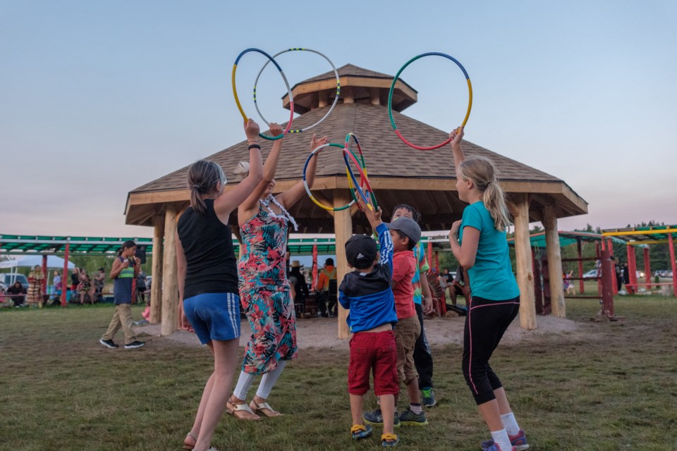 Becky Beaudry of Wikwemikong (in the pink and blue dress) gave children lessons in traditional hoop making and then led them through a hoop dance at the Garden River Pow Wow on August 12, 2017. Jeff Klassen/SooToday