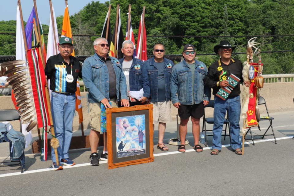 Members of the 'original six' who helped paint the Garden River train bridge, along with the descendents of two fallen members, pose for a picture during the 50th anniversary commemoration of the iconic 'This Is Indian Land' bridge on National Indigenous Peoples Day. 