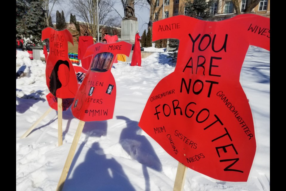 Signs in the shape of red dresses adorn Queen Street during a 2020 Missing and Murdered Indigenous Women and Girls  memorial march in Sault Ste. Marie. (James Hopkin/SooToday)