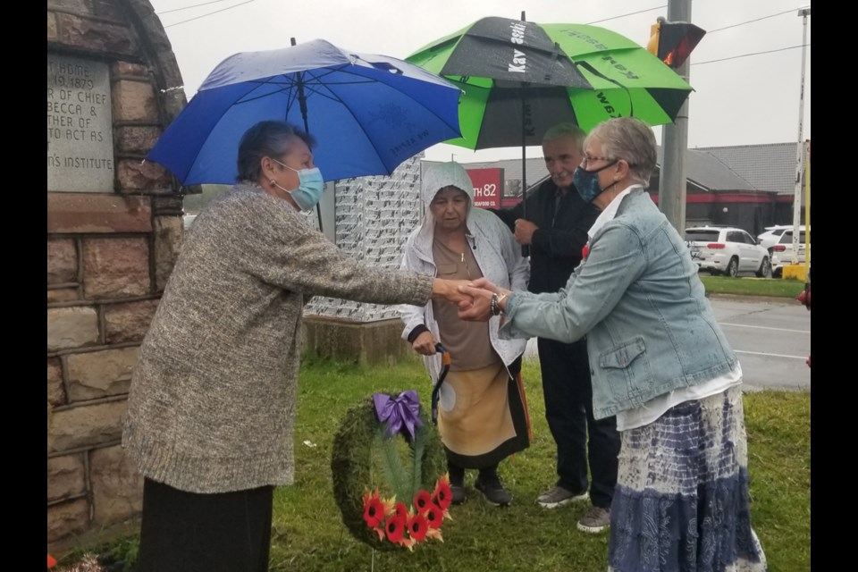 Shingwauk Indian Residential School survivor Shirley Horn, left, shakes hands with Royal Canadian Legion Branch 25 President Helen Stewart after Stewart laid a wreath down at the Wawanosh Home for Girls monument during a ceremony Saturday. Left to right: Horn, her sister and fellow Shingwauk survivor Jackie Fletcher, SalDan general manager Sam Biasucci and Stewart. 