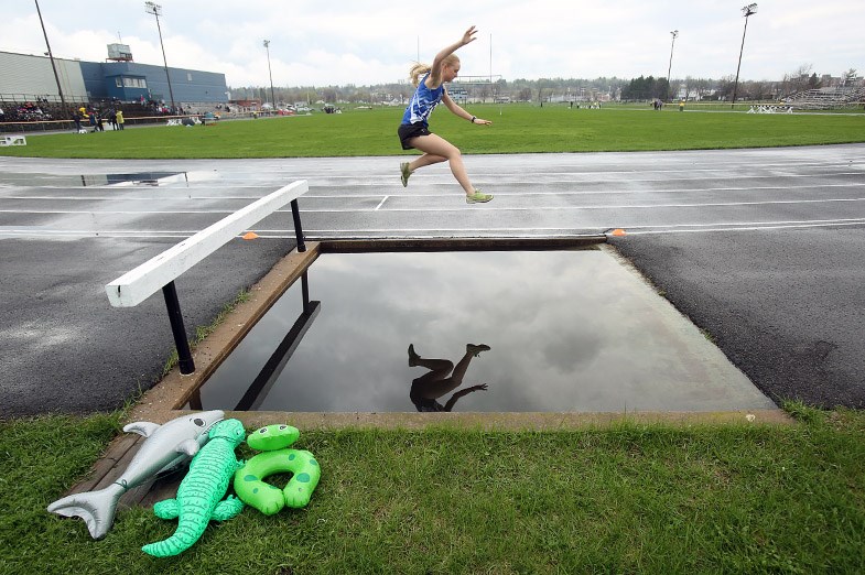 Superior Heights runner Erika Mihell jumps over the water barrier before finishing first in the 1500 meter steeplechase. SooToday.com/Kenneth Armstrong