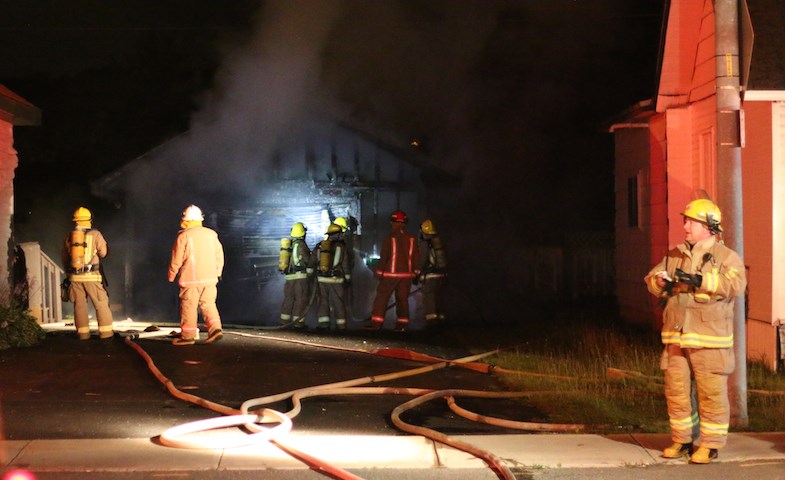 Sault Ste. Marie Fire Service crews tend to a garage fire that broke out late Friday, August 1, 2014 on Wellington Street East near Pine Street
