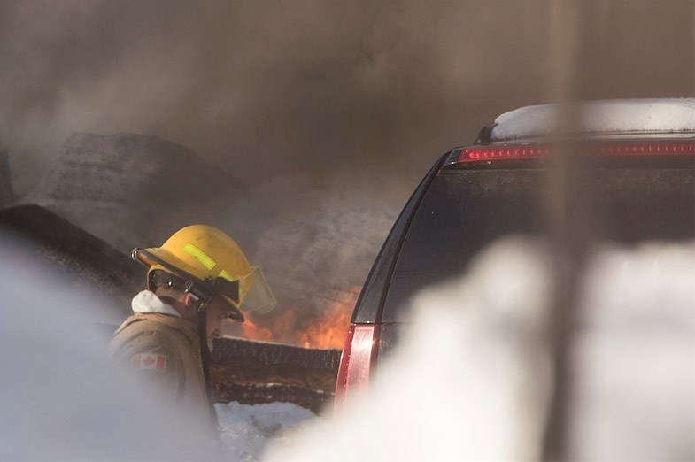 Firefighter on the scene of a house fire on February 27, 2015 in the Fifth Line and Old Highway 17 area in Sault Ste. Marie. Kenneth Armstrong/SooToday