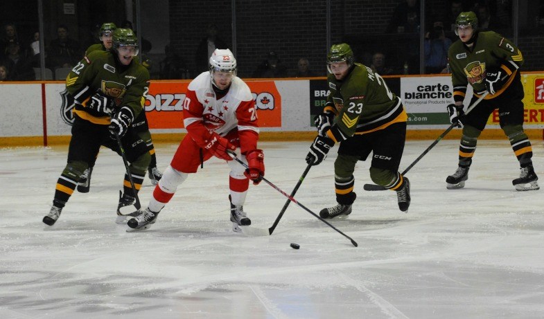Soo Greyhounds forward Nick Ritchie (centre) battles for a loose puck with two North Bay Battalion players. Tom Martineau/BayToday